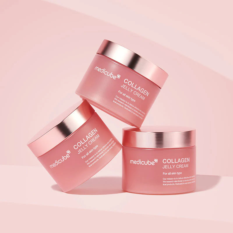 Três frascos fechados Medicube Collagen Jelly Cream dispostos em ângulo sobre rosa