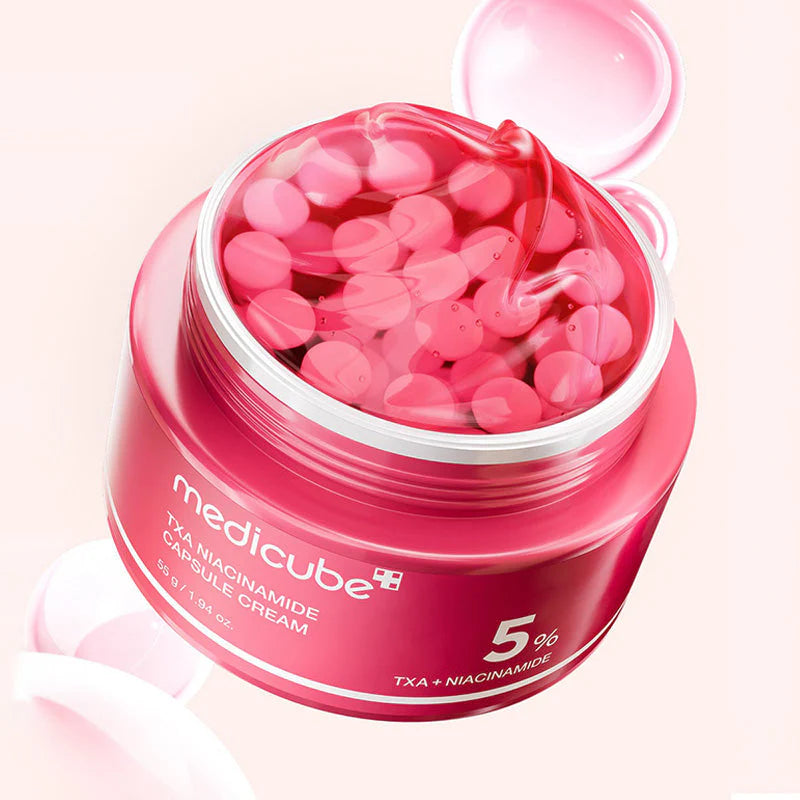 Boião do TXA Niacinamide Capsule Cream com a tampa ao lado e textura a transbordar