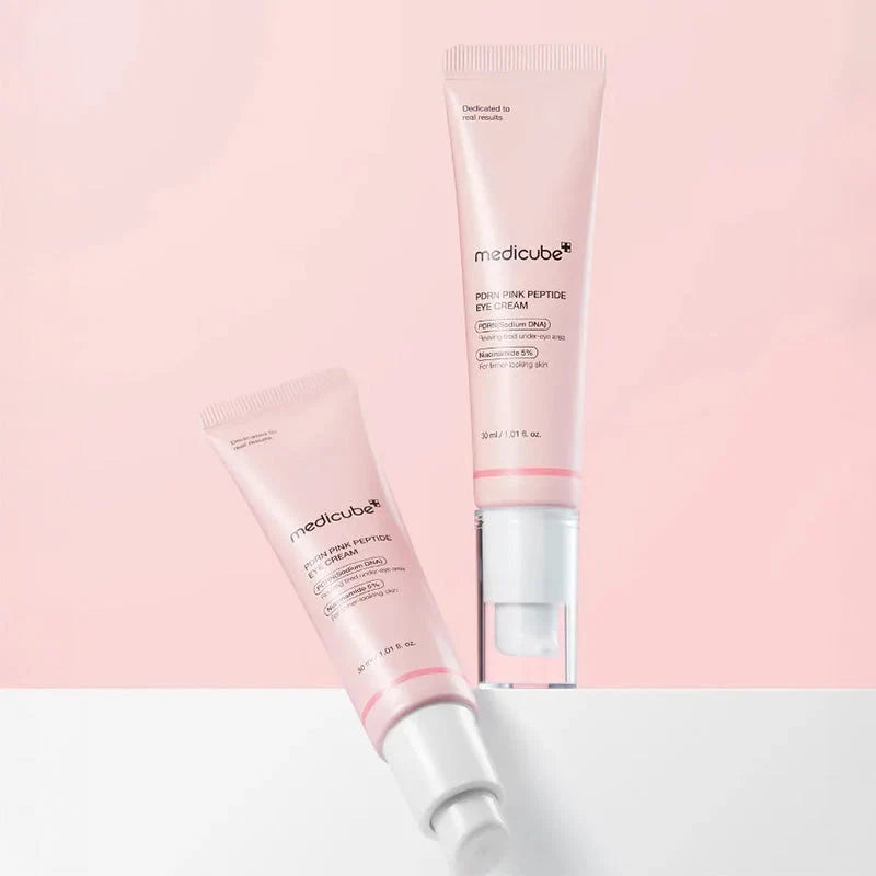 Duas embalagens Medicube, uma de pé e outra inclinada, sobre fundo rosa e branco