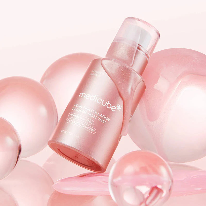 Frasco do sérum PDRN Medicube rodeado por esferas translúcidas cor de rosa