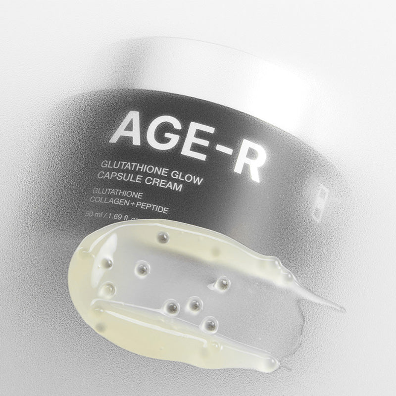 Amostra de textura do creme com cápsulas translúcidas sobre o rótulo do frasco AGE-R