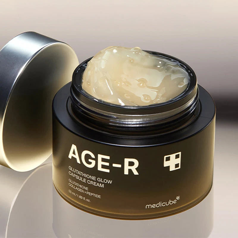 Frasco aberto do creme Medicube com a tampa metálica ao lado e a textura visível no interior