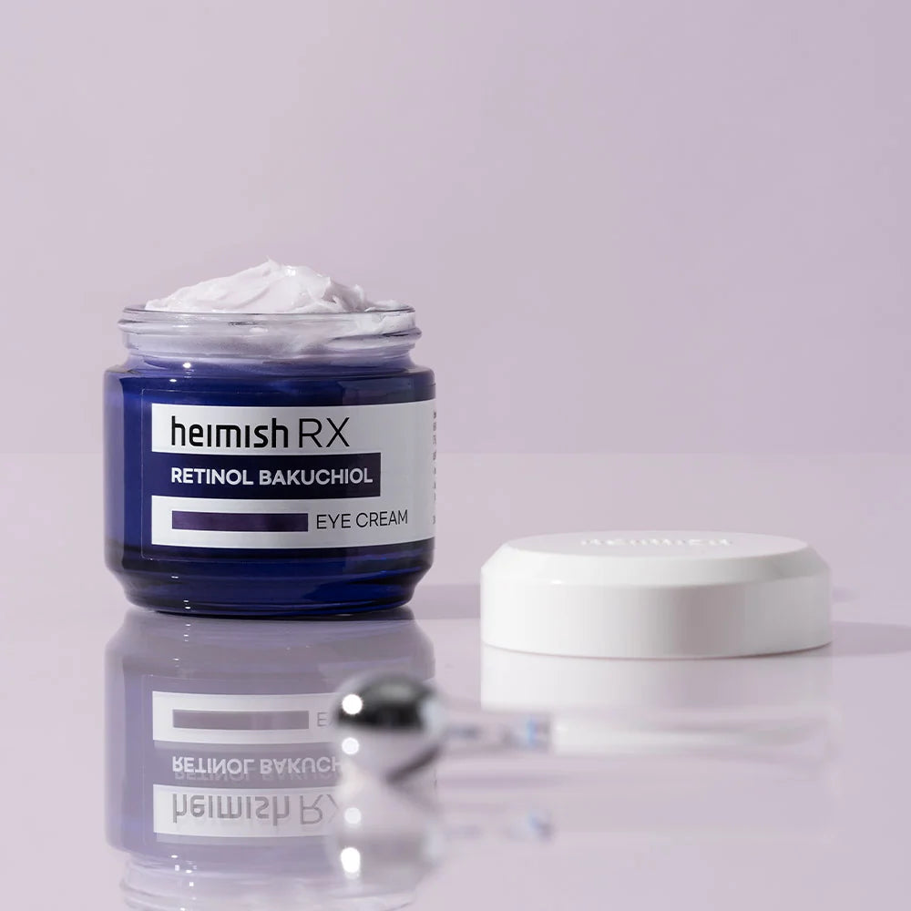 Heimish RX Retinol Bakuchiol Eye Cream aberto, creme e aplicador metálico sobre superfície refletora