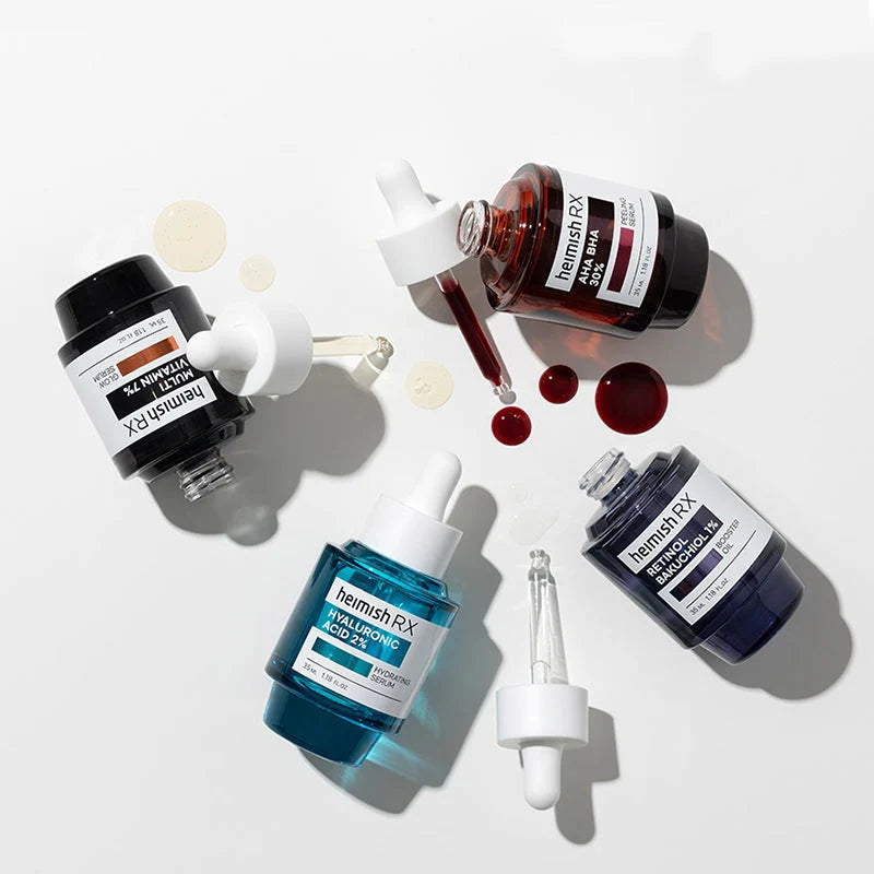 Frascos da linha Heimish RX inclinados com gotas de sérum a cair sobre fundo branco