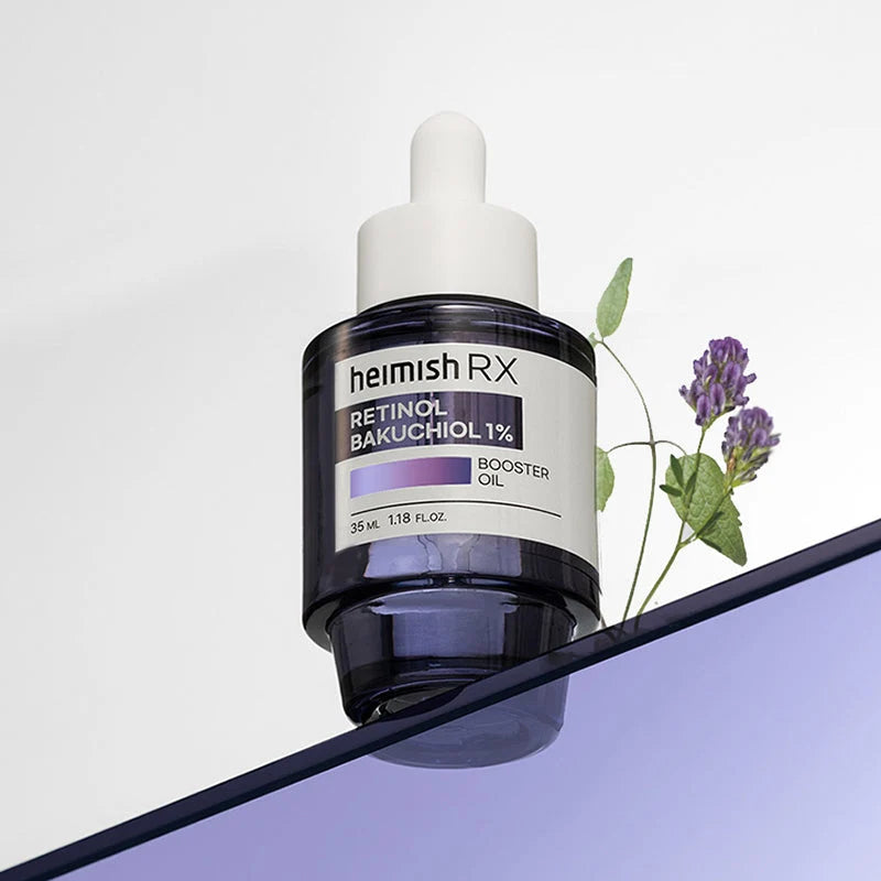 Frasco do Heimish RX Retinol Bakuchiol Booster Oil inclinado junto a um ramo de lavanda