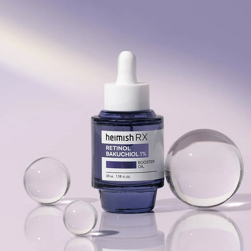 Frasco do Heimish RX Retinol Bakuchiol Booster Oil entre esferas de vidro transparentes