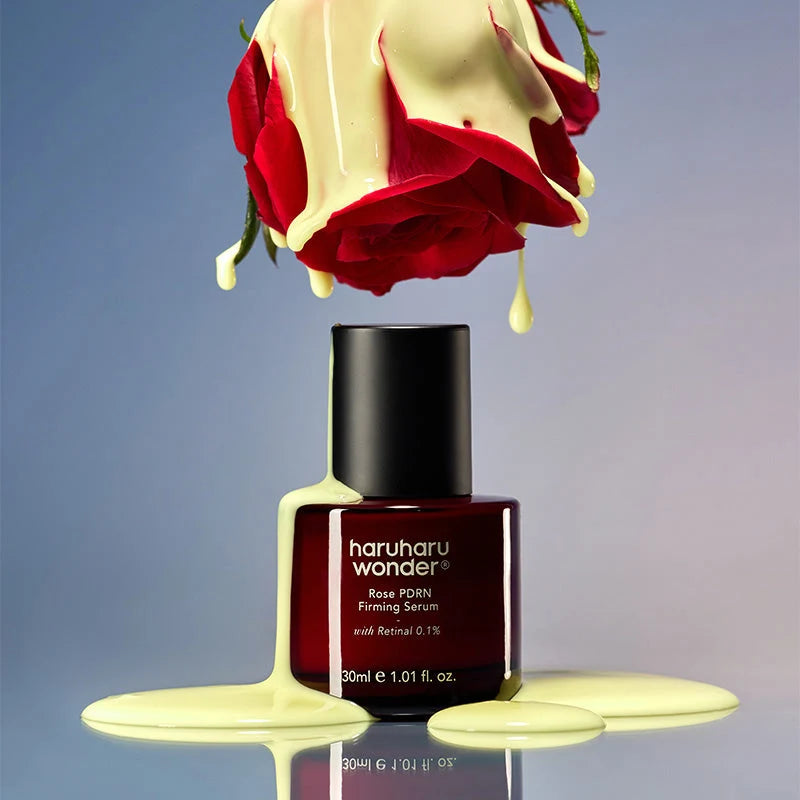 Textura cremosa a escorrer de uma rosa sobre o frasco do Rose PDRN Firming Serum