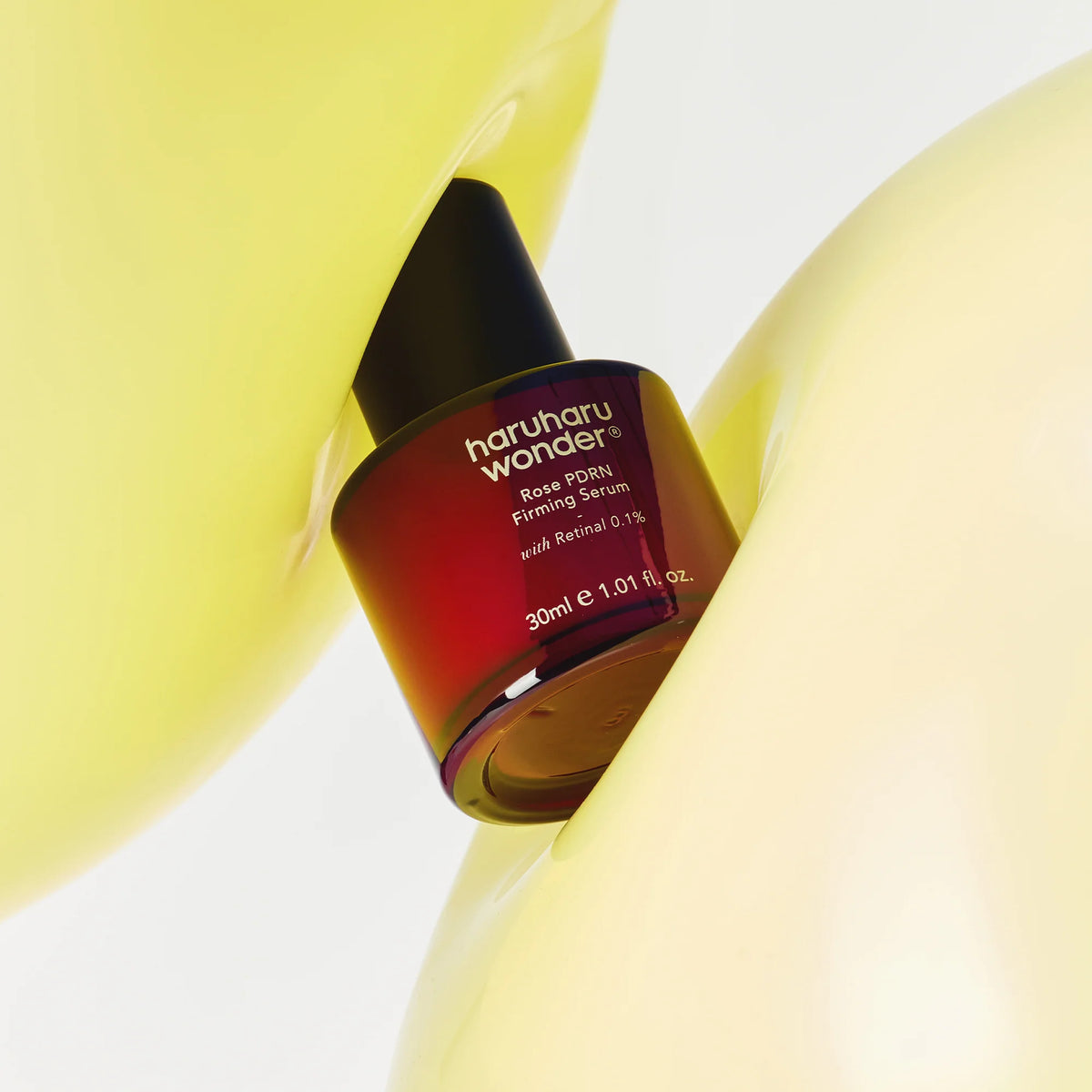 Frasco do Rose PDRN Firming Serum encaixado entre formas amarelas e arredondadas