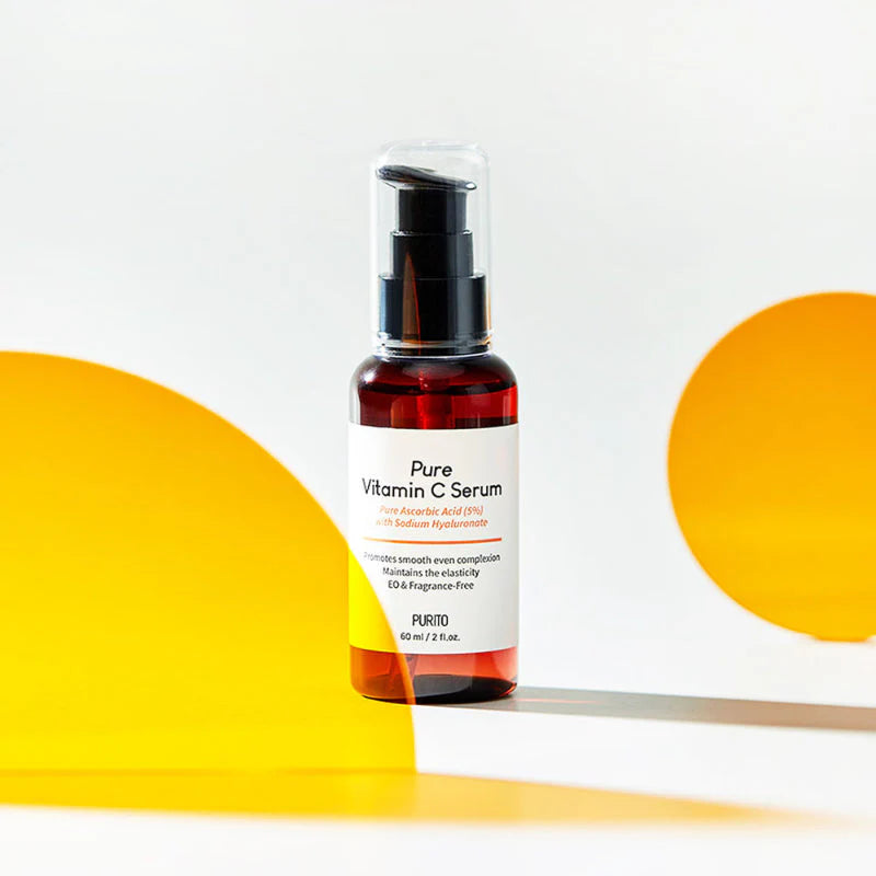Purito Seoul Pure Vitamin C Serum garrafa âmbar com doseador sobre fundo amarelo e cinzento