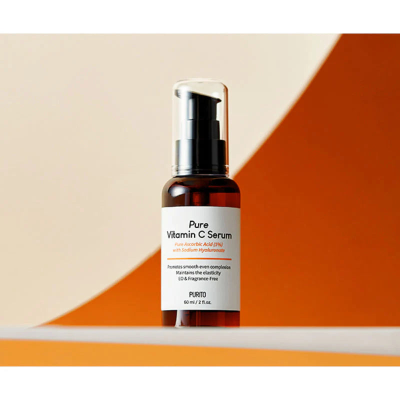 Purito Pure Vitamin C Serum frasco âmbar com bomba sobre fundo laranja e bege