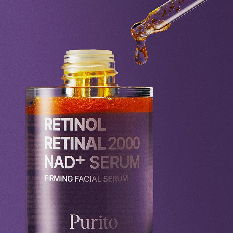 Frasco aberto com o conta-gotas a pingar sérum com partículas cor de âmbar, sobre fundo roxo escuro