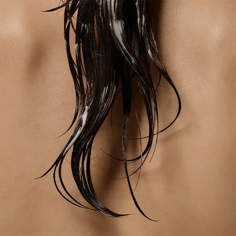 Creme Growus aplicado em madeixas de cabelo húmido, textura branca visível nos fios