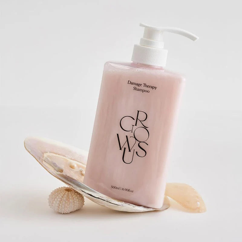 Frasco do Growus Damage Therapy Shampoo pousado sobre uma concha marinha