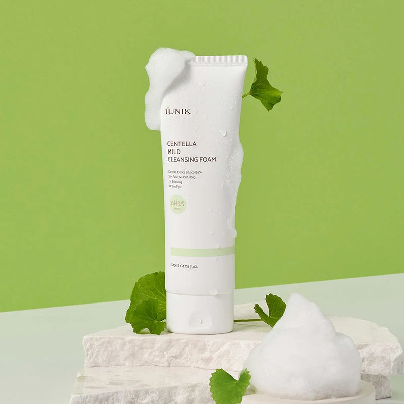 IUNIK Centella Mild Cleansing Foam sobre pedra, com folhas de centella asiática