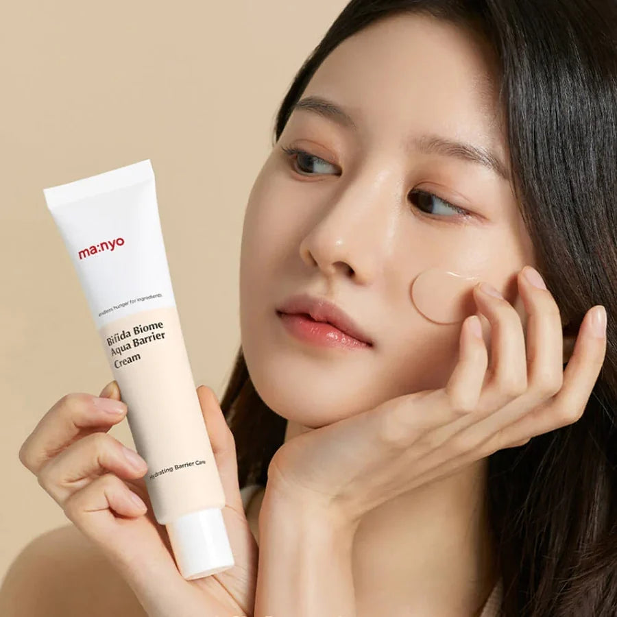 Modelo aplica o creme ma:nyo Bifida Biome no rosto, mostrando a absorção rápida