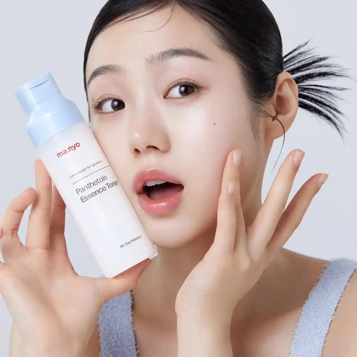 ma:nyo Panthetoin Essence Toner, frasco com tampa azul junto ao rosto