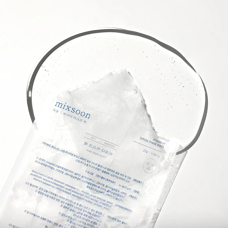 Saqueta aberta da mixsoon Bifida Mask sobre fundo húmido, com lista de ingredientes visível no verso