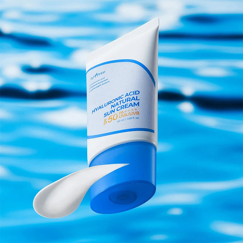 Isntree Hyaluronic Acid Natural Sun Cream sobre fundo azul de água, com uma porção da textura do creme