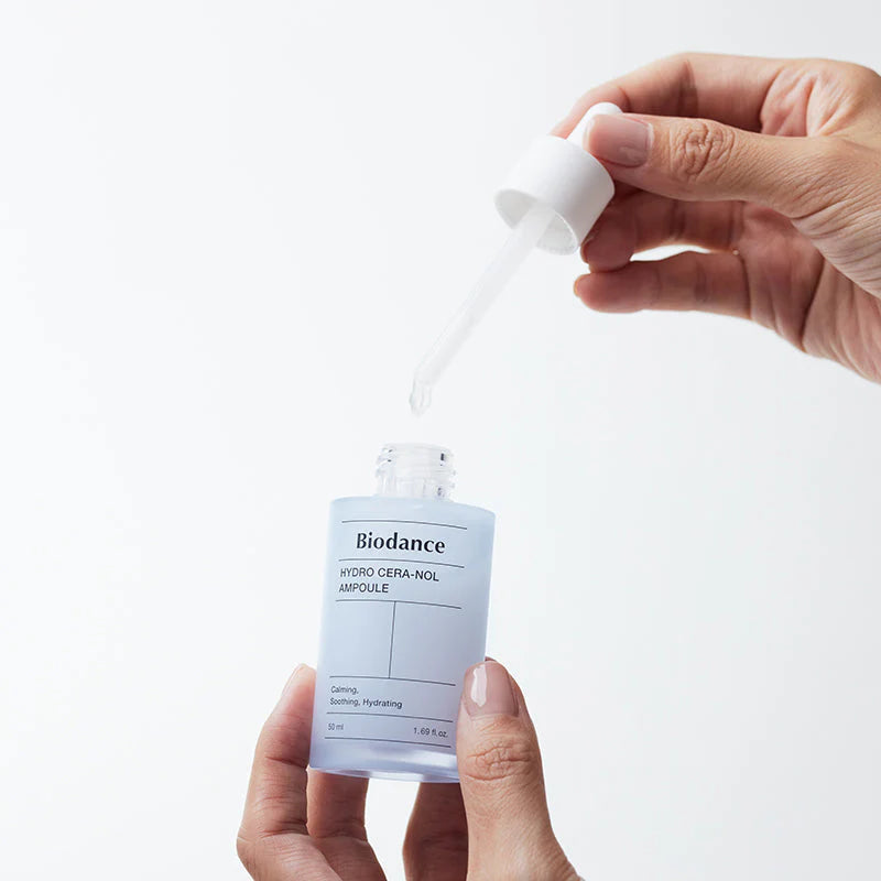 Biodance Hydro Cera-Nol Ampoule – mãos a retirar o conta-gotas do frasco aberto