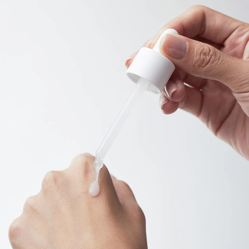 Textura sérica translúcida da Biodance Hydro Cera-Nol Ampoule aplicada sobre a pele com conta-gotas