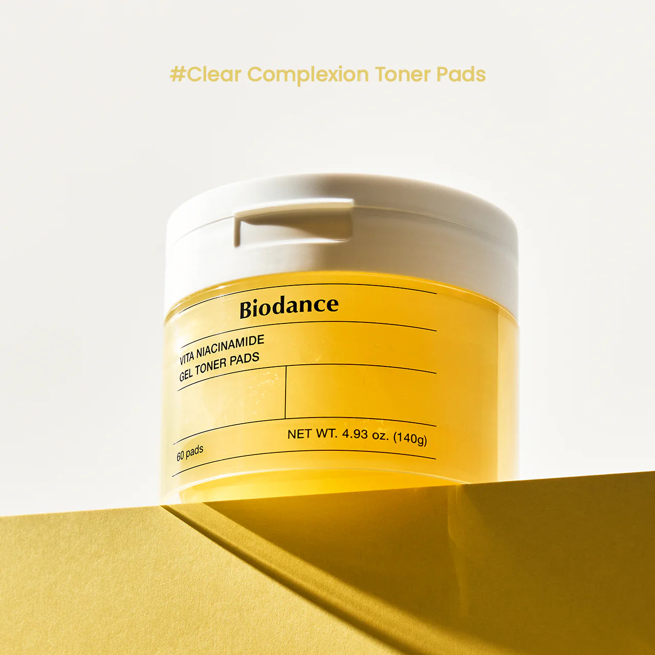 Boião Biodance Vita Niacinamide Gel Toner Pads em fundo amarelo, plano aproximado