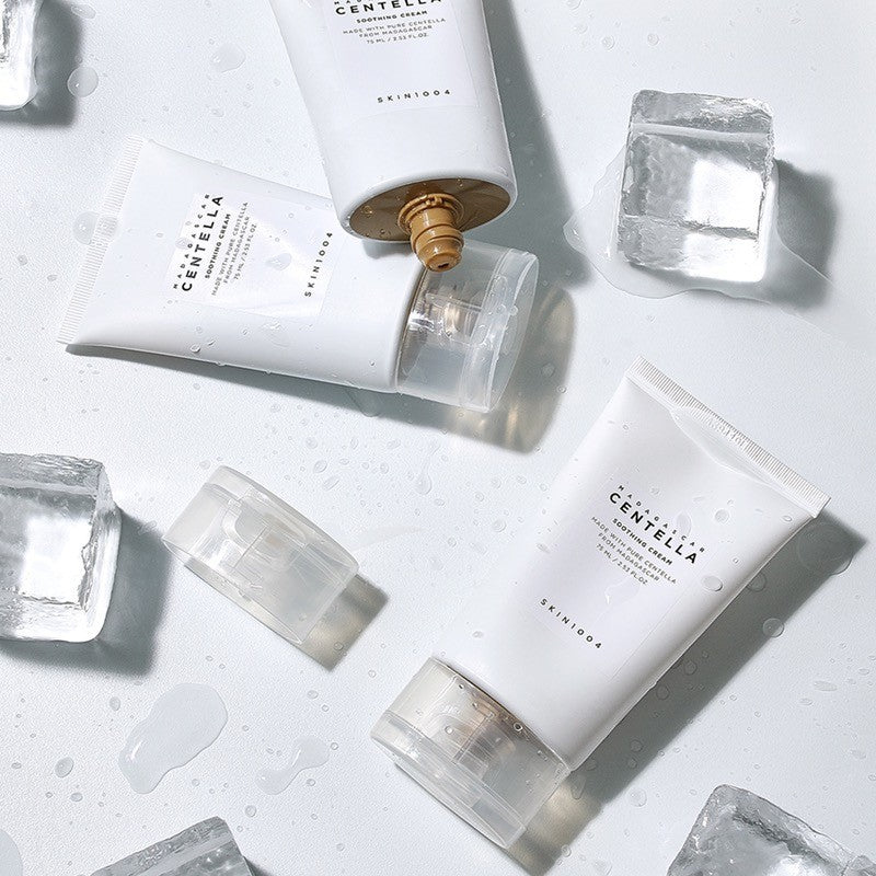 Tubos SKIN1004 Madagascar Centella Soothing Cream rodeados de cubos de gelo e gotas de água