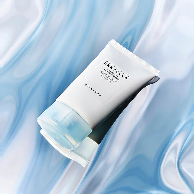 SKIN1004 Hyalu-Cica Moisture Cream embalagem tube 75ml sobre fundo azul marmoreado
