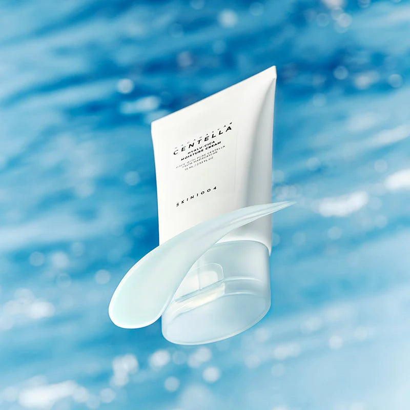 SKIN1004 Hyalu-Cica Moisture Cream embalagem com tampa azul aberta, fundo oceano desfocado