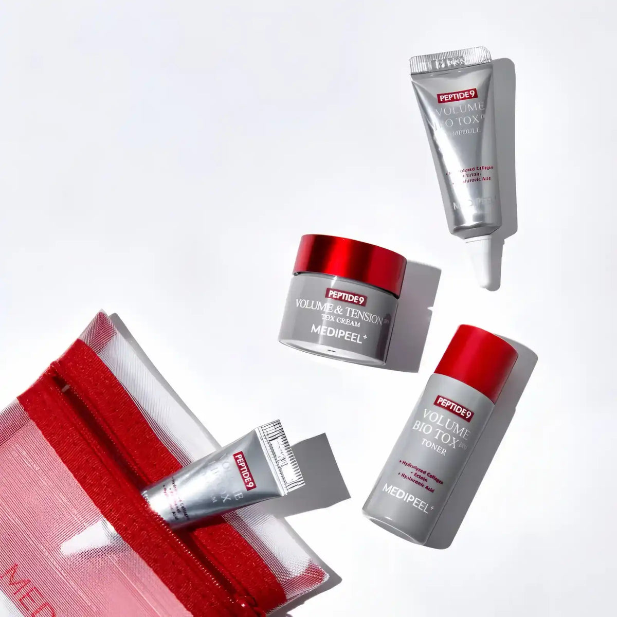 Pote de creme, tubo de ampola, tónico e creme de olhos soltos junto à bolsa de rede com fecho vermelho